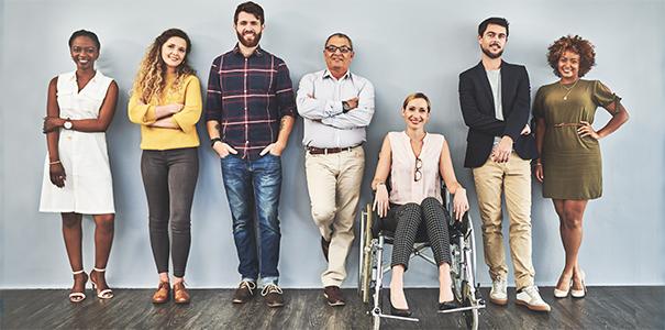 Diverse group of business people standing against a blue wall